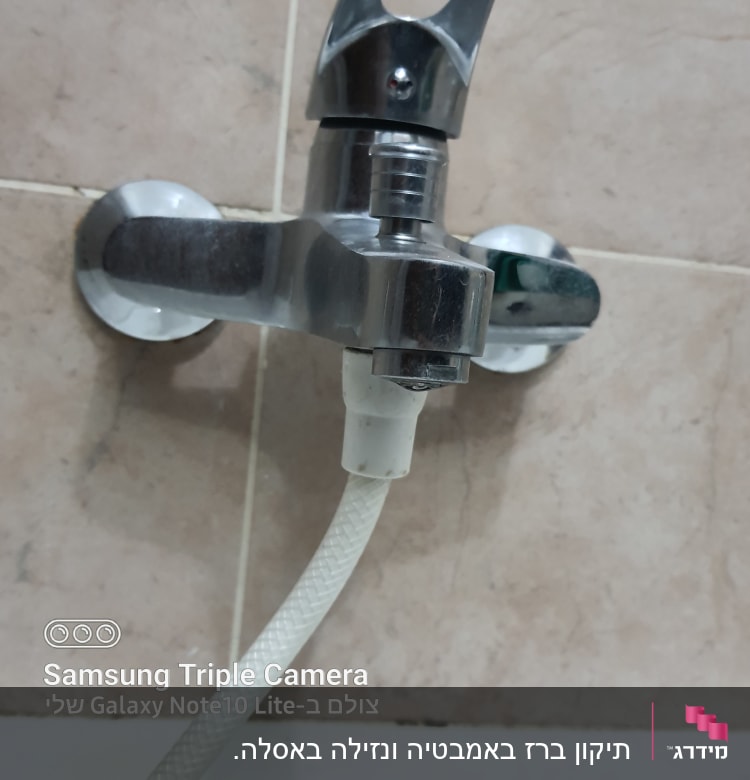 ברז מתכת עם צינור מחובר לקיר